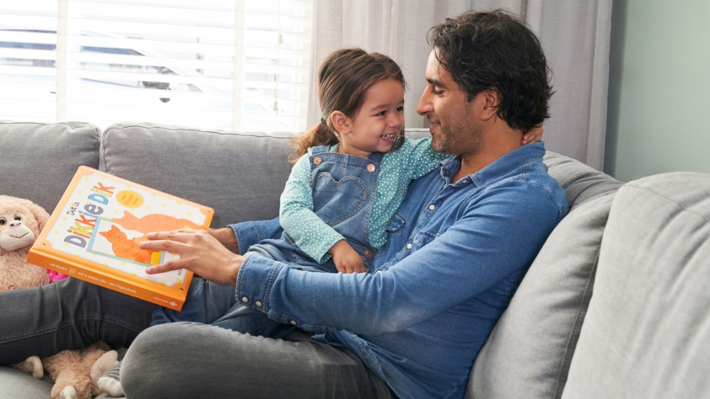 vader met dochter op de bank met voorleesboek